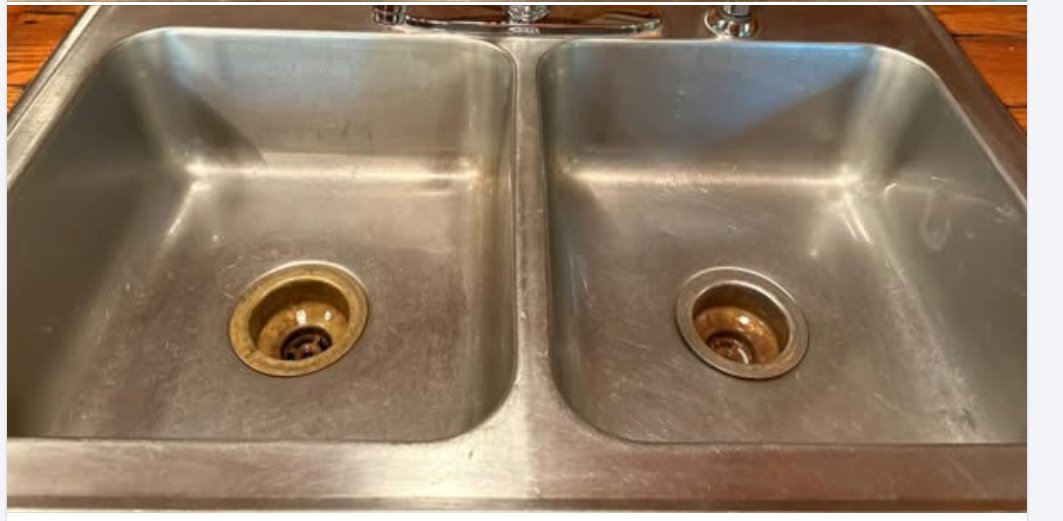 A double kitchen sink after Clear Pathways cleaned it — bright stainless, clear drains.