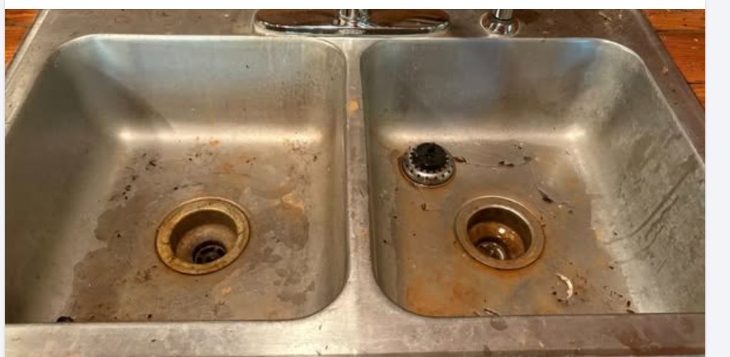 The same double kitchen sink before cleaning — grime, rust stains, and debris.
